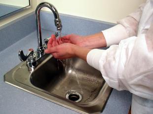 Lab tech washing hands in sink