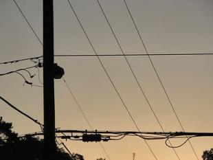 electrical lines silhouetted against a sunset
