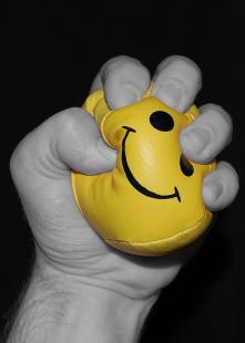 Man clutching stress ball angrily