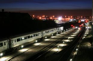 Train running through a train yard at high dusk