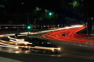 Car zipping around a corner with a light trail